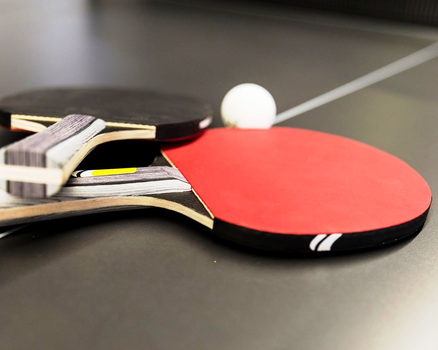Ping pong rackets and ball on black table tennis